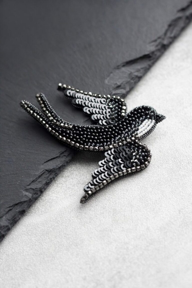 Broche en forme d’oiseau fixée sur un vêtement élégant.
